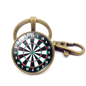 Close-up of vintage bronze dartboard keychain with glass dome and score numbering