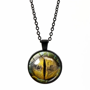 Détail du pendentif œil de dragon avec iris jaune en verre et chaîne en métal noir