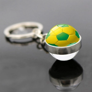 Macro d'un porte-clés ballon de foot en verre aux couleurs jaune et vert du Brésil