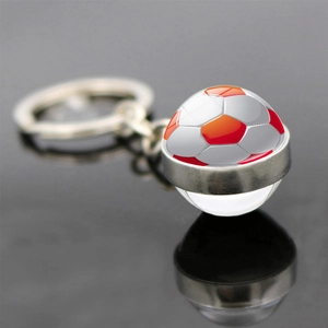 Vue macro d'un porte-clés en verre de football avec chaîne en métal argenté poli