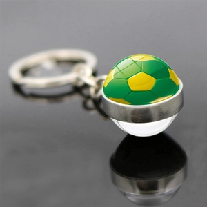 Porte-clés ballon de football en cristal avec anneau en argent sur fond noir réfléchissant