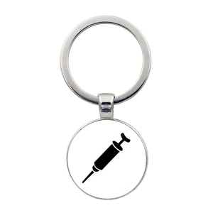 Detail of silver alloy keychain featuring a black syringe silhouette on a round pendant