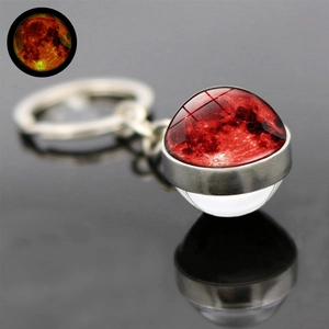 Macro shot of Blood Moon glass ball pendant on silver alloy keychain with reflection