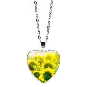 Primo piano dettagliato di una collana con ciondolo a cuore argentato e motivo girasole