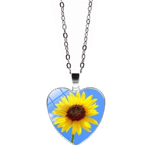 Dettaglio della collana con ciondolo a cuore, motivo girasole e catenina argentata