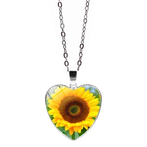 Dettaglio della collana con ciondolo a cuore e girasole in argento su una catena lunga