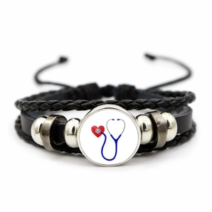 Detail of medical nurse bracelet with leather straps and heart stethoscope glass charm