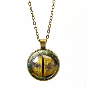 Macro detail of retro bronze pendant with a yellow dragon eye glass cabochon texture