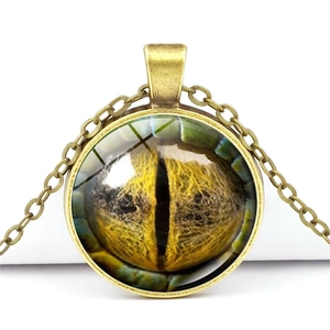 Detailed close-up of a bronze dragon eye pendant with yellow glass eyeball inlay