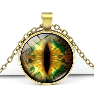 Detailed close-up of a vintage bronze dragon eye pendant necklace on a white background
