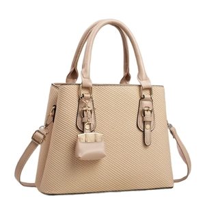 Beige canvas texture tote bag with leather straps and mini charm accessory