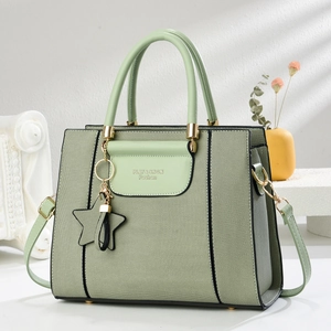 Détail du sac à main vert pastel tissé avec bandoulière en cuir et charm en étoile