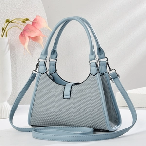 Detail of light blue leather and grey canvas patchwork bag with stitching textures