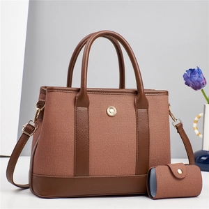 Détail du cabas en toile marron bicolore avec fleur en métal et bandoulière réglable