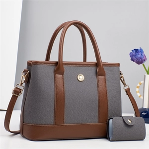 Détail du sac cabas en toile bicolore avec bordure en cuir et boucle tournesol