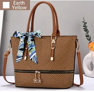 Dettaglio della borsa a secchiello giallo terra con trama intrecciata e foulard in seta