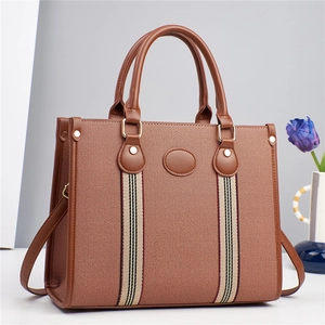 Détail du sac cabas en toile marron avec sangles rayées et poignées en similicuir