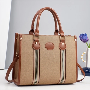 Détail d'un sac cabas rétro en toile avec garniture en cuir marron et bandoulière