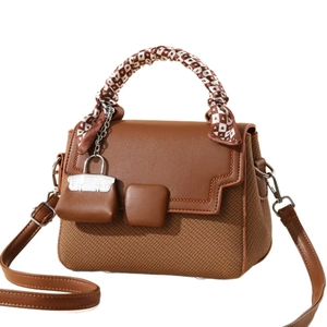 Brown woven crossbody bag with vintage style handle and heart patterned silk scarf detail