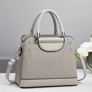 Sac à main plissé beige élégant avec détails argentés et décor d'orchidées en studio