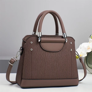 Détails du sac à main marron foncé montrant la texture ondulée et les ferrures argentées