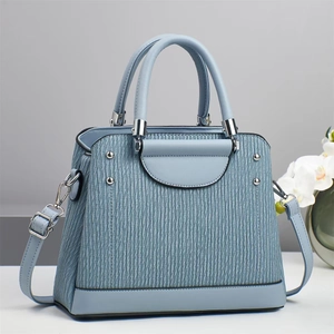 Sac à main élégant en cuir gaufré bleu clair avec rivets argentés et bandoulière amovible