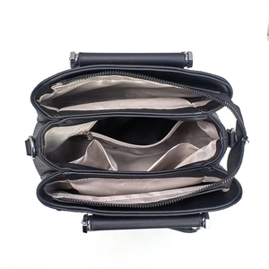 Intérieur du sac à main noir avec trois compartiments et doublure chevron beige