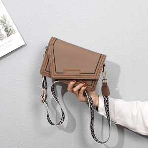 Close-up of khaki envelope bag featuring wave embroidery and jacquard shoulder strap