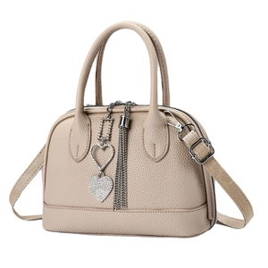 Sac à main beige texture litchi avec pendentif coeur diamant et détail de long gland