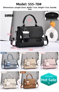 Detailed view of canvas crossbody bag with dimensions 23x11x17cm and mini charm accessory