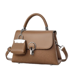 Borsa a mano marrone in pelle e tessuto intrecciato con fibbia tonda e mini ciondolo