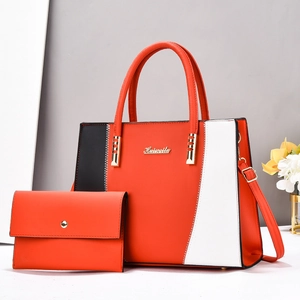 Détail du sac cabas bicolore avec coutures en zigzag et logo de marque en métal