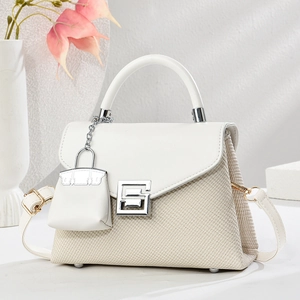 Elegant woven beige and white crossbody bag with geometric metal lock and mini charm