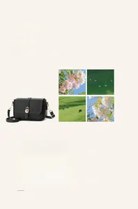 Détail d'un sac à main en cuir grainé noir avec fermoir tournant doré et bandoulière
