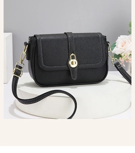 Détail du sac à main en cuir grainé noir avec coutures contrastées et fermoir doré