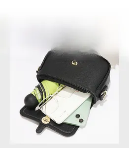 Vue intérieure d'un sac bandoulière en cuir noir montrant sa grande capacité de rangement