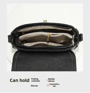 Détail de l'intérieur du sac à main noir avec trois compartiments et doublure beige