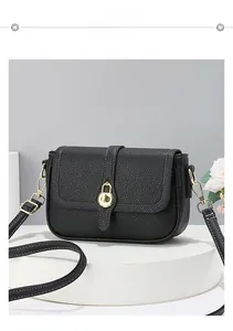 Détail du sac à main noir texture litchi avec surpiqûres blanches et boucle dorée