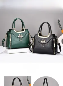 Detail of PU leather tote bags showing golden swan charms and litchi grain texture