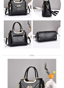 Detail view of black lychee grain handbag with gold hardware and protective base studs