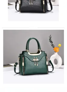 Close-up of vintage leather handbag with swan metal ornament and pearl tassel detail