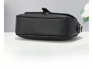 Détail macro de la base en cuir épaissie et des coutures fines du sac à bandoulière noir