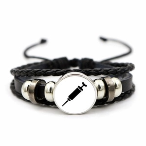 Detailed close-up of handmade leather bracelet with medical syringe glass dome pendant