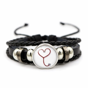 Detail of woven leather bracelet featuring a red heart stethoscope glass pendant