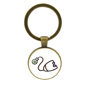 Close-up of bronze metal keychain with stethoscope glass dome pendant for nurses