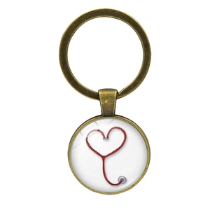Close-up of bronze keychain pendant with red stethoscope heart design under glass