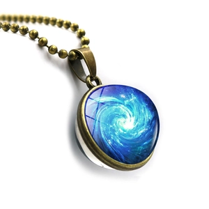 Macro shot of cosmic blue spiral galaxy pendant with bronze frame and glass dome