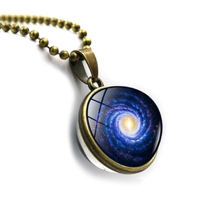 Close-up of double-sided glass galaxy pendant with cosmic vortex on bronze chain