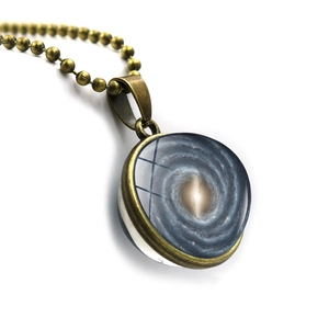 Detail view of retro bronze space galaxy glass pendant with celestial vortex pattern