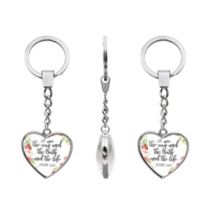 Detail of heart keychain with Bible verse John 14:6 and floral design on white background